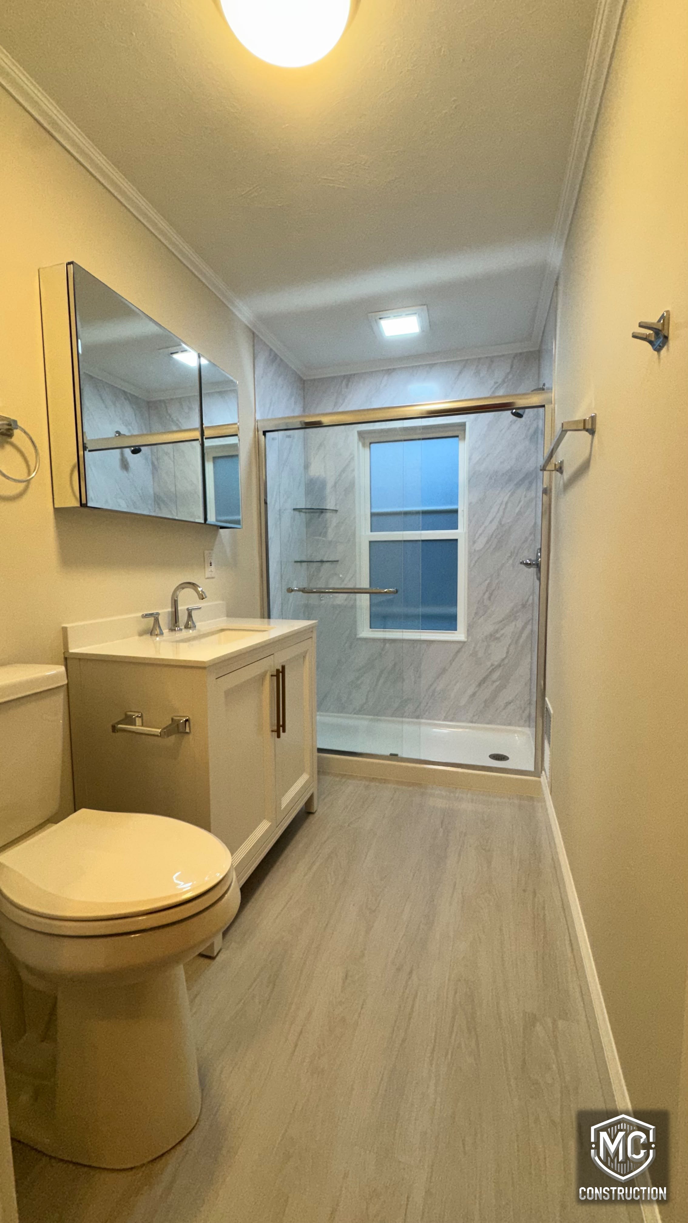 Renovated bathroom with glass shower door, new vanity and modern finishes in Natick, MA